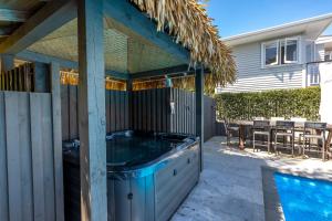 a hot tub in the backyard of a house at Aloha Cottage with Pool & Spa, Waiheke in Oneroa