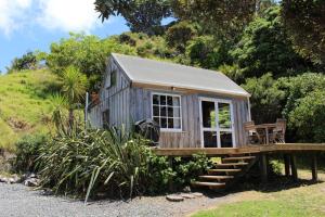 une petite maison avec un porche et une terrasse dans l'établissement OCEANSIDE - Exclusive & private - Castaway Cottage, à Tuateawa