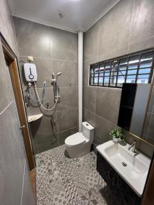 a bathroom with a toilet and a sink at Homestay by Tas in Kulai +10 photos