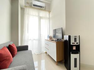Телевизор и/или развлекательный центр в Cozy Stay 1BR at Vasanta Innopark Apartment By Travelio