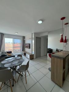 a kitchen and living room with a table and chairs at Apto com elevador, muito ventilado e aconchegante in Anil