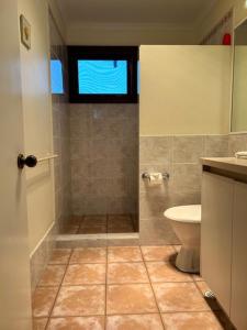 a bathroom with a shower with a toilet and a window at Ashleigh - In Town - Margaret River in Margaret River Town +25 photos