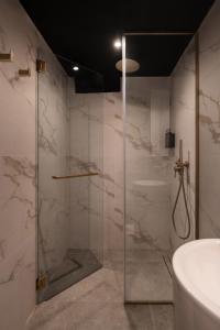 a bathroom with a glass shower with a sink at Cube Social Boutique Capsule Hotel at Boat Quay in Singapore