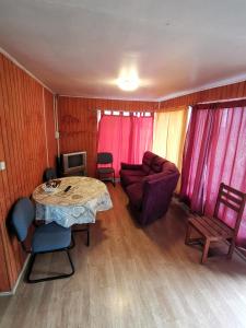 a living room with a table and a couch at Hostal y Cabañas Maribel Zuñiga in Valdivia