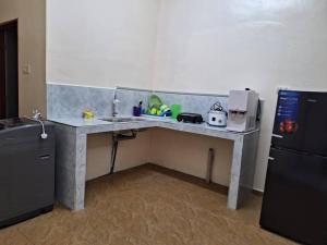 a kitchen with a counter with a sink and a refrigerator at D'Bilal Zainal Homestay !Free Wifi, Free Netflix! in Bukit Baru
