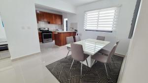 a kitchen and dining room with a glass table and chairs at Proximo al Hospital HOMS 3 minutos monumento in Hato Mayor