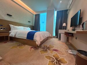 a bedroom with a bed and a television in it at 海岸秀月楼酒店 in Shenzhen