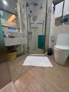 a bathroom with a shower and a toilet and a sink at 海岸秀月楼酒店 in Shenzhen