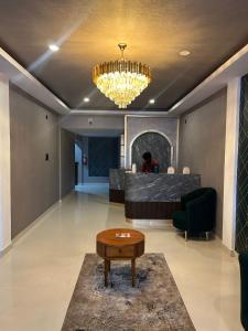 un soggiorno con tavolo e lampadario pendente di Jaya Tourist Home a Varkala