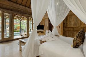 a bedroom with a bed with white drapes at Astala Ubud Villa in Ubud +62 photos