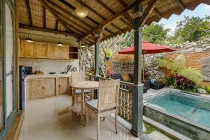 an outdoor kitchen with a table and a swimming pool at Astala Ubud Villa in Ubud