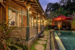 an exterior view of a house with a swimming pool at Astala Ubud Villa in Ubud
