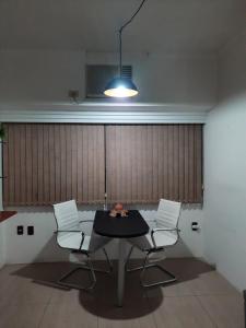 a dining room with a table and two chairs at Flat, Hotel Imperial Suites - Recife in Recife