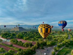 a group of hot air balloons flying over the pyramids at Gran Tonantzin in San Martín de las Pirámides