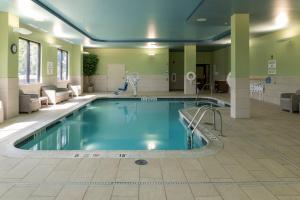 a large swimming pool in a large room with chairs at Holiday Inn Express - Grand Island by IHG in Niagara Falls