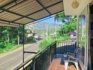 a porch with a chair on a balcony with a view of a road at SECRET MIRAGE Ella in Ella