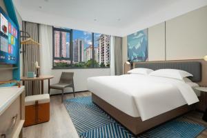 a bedroom with a large white bed and a large window at Echarm Hotel Guangzhou East Railway Station South China Normal University Metro Station in Guangzhou +28 photos