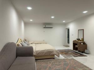a bedroom with a bed and a couch at AL- aqyr Rest Garden أستراحة حارة العقر in Nizwa