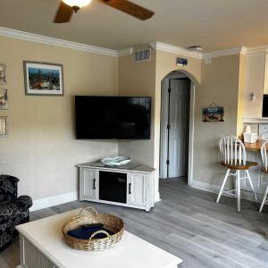 a living room with a flat screen tv on the wall at Tortuga Inn Beach Resort Unit #229 in Bradenton Beach