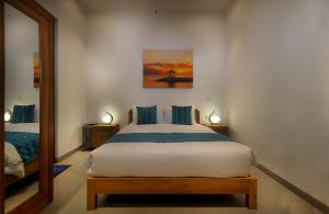 sypialnia z dużym łóżkiem i lustrem w obiekcie Villa Casa Turtle Sanur 3 Bedrooms Pool Villa w mieście Sanur +18 zdjęć