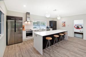 a kitchen with a refrigerator and a counter with stools at Oceania @ Cape Villas Dunsborough in Dunsborough