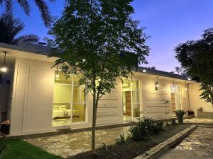 a white house with a tree in front of it at AL- aqyr Rest Garden أستراحة حارة العقر in Nizwa