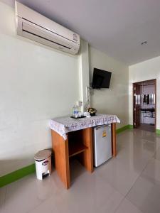 拉廊ลูกจ่าปองโฮม Lukjapong Home的厨房配有带水槽的柜台和冰箱。