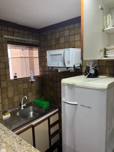 a small kitchen with a sink and a microwave at Pier Sul Apart Service in Salvador