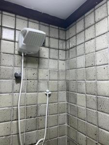 a shower with a phone on a tiled wall at Pier Sul Apart Service in Salvador