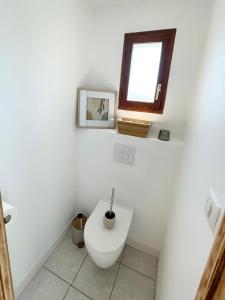 une salle de bain blanche avec toilettes et fenêtre dans l'établissement Vacation home in Etaples - near to Le Touquet, à Étaples