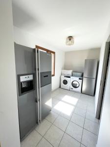 d'une cuisine équipée d'un réfrigérateur en acier inoxydable et d'un lave-linge. dans l'établissement Vacation home in Etaples - near to Le Touquet, à Étaples