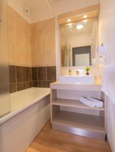 a bathroom with a sink and a tub and a mirror at Appartement 2 Pièces 2/4 Personnes MAE-0981 in Le Mélézet