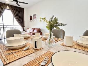 a dining room with a table with white plates at Next to BRT station near Sun-Med Sun-Uni & Lagoon in Kampong Penaga