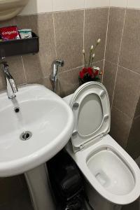 a bathroom with a white sink and a toilet at Krystal Claine Homestay-BURNHAM HILL in Baguio +34 photos