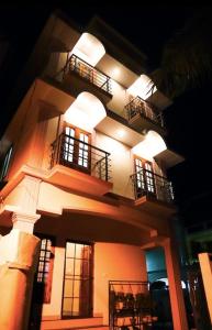 un edificio alto con balconi e luci di Guestland Homestay a Cochin