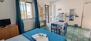 a bedroom with a bed and a table and a kitchen at MAREE SOL RESIDENCE Camere e Appartamenti in Torre San Giovanni Ugento
