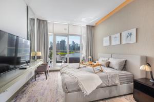 ドバイにあるLivin' Holidays - Luxury studio with Bay viewのベッドルーム(大型ベッド1台、テレビ付きテーブル付)