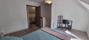 a bedroom with a bed and a chair in it at Maison DEOLS centre 41 pour 1 ou 2 personnes in Déols
