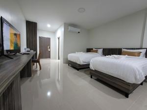 a bedroom with two beds and a flat screen tv at Royal Creek Golf Club And Resort in Udon Thani