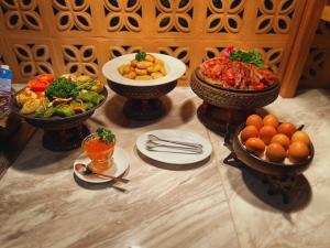 a table with plates of food and bowls of food at Villa Sirilanna Hotel in Chiang Mai