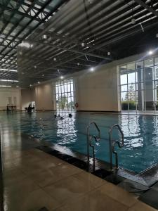 a large indoor swimming pool with swimmers in it at Cool Suites SMDC Tagaytay in Tagaytay