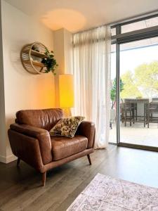 a brown leather chair sitting in a living room at Beach Front Dream Lifestyle in Auckland +29 photos