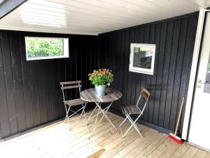 un patio con mesa, sillas y una maceta en Nice log house close to Lillehammer and Sjusjøen, en Haugen