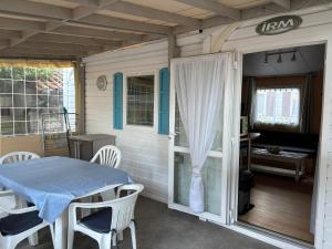 a small room with a table and chairs on a porch at Joli bungalow in Meschers-sur-Gironde