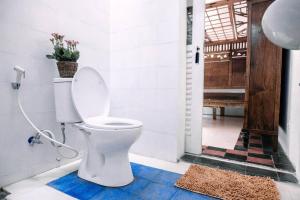 La salle de bains est pourvue de toilettes et d'une plante. dans l'établissement Vintage Room 1 in Joglo House By penggemarlawas, à Kamparganya