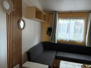a living room with a couch and a window at Joli bungalow in Meschers-sur-Gironde
