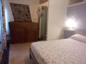 a bedroom with a bed and a dresser in a room at BARDI AL RIOLO Robinia Apt in Bardi