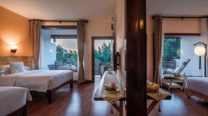 a hotel room with two beds and a balcony at Snow Lion Riverside Resort in Yangshuo