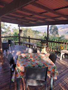 a table and chairs on a deck with a view at Proteahill Guesthouse in Drummond
