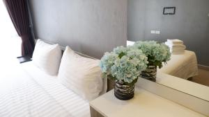 a bedroom with two vases of flowers on a bed at 18 Residence in Bangkok